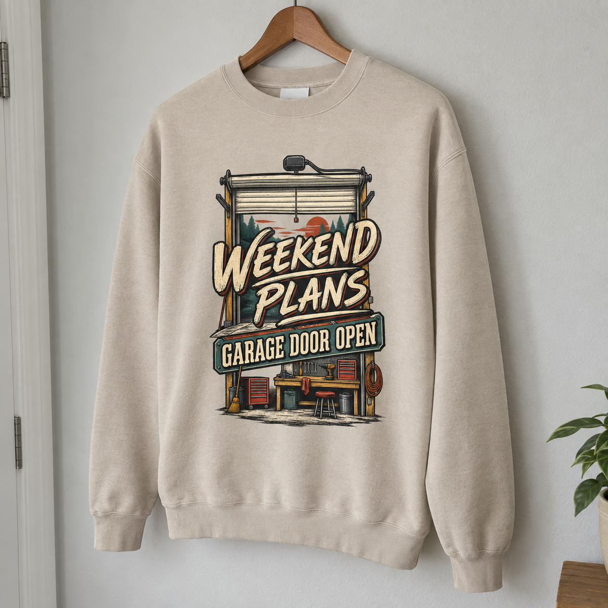 Vintage sweatshirt with printed Weekend Plans Garage Door Open design, hanging on a wooden hanger
