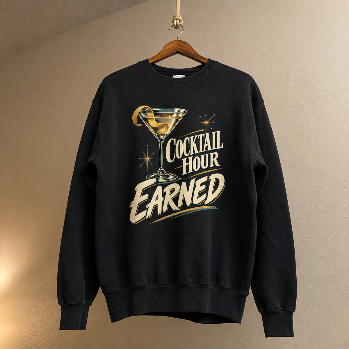 Black vintage sweatshirt hanging with printed Cocktail Hour Earned slogan and cocktail graphic