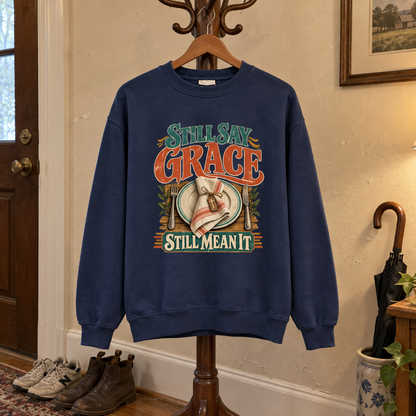Navy vintage sweatshirt hanging with printed Still Say Grace Still Mean It design