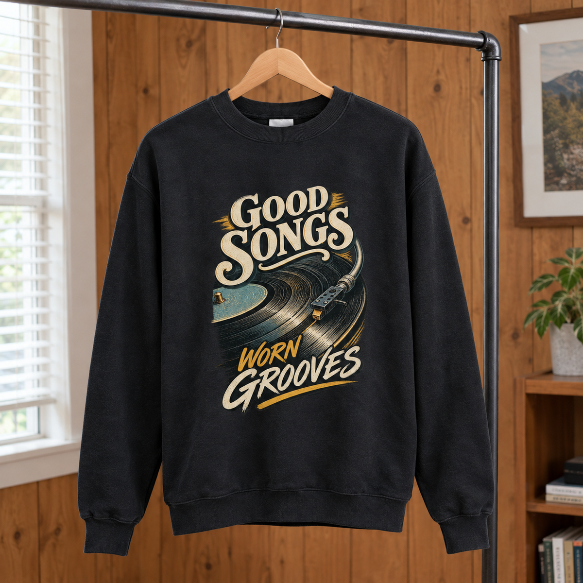 Black vintage sweatshirt with printed Good Songs Worn Grooves slogan hanging on wooden rack