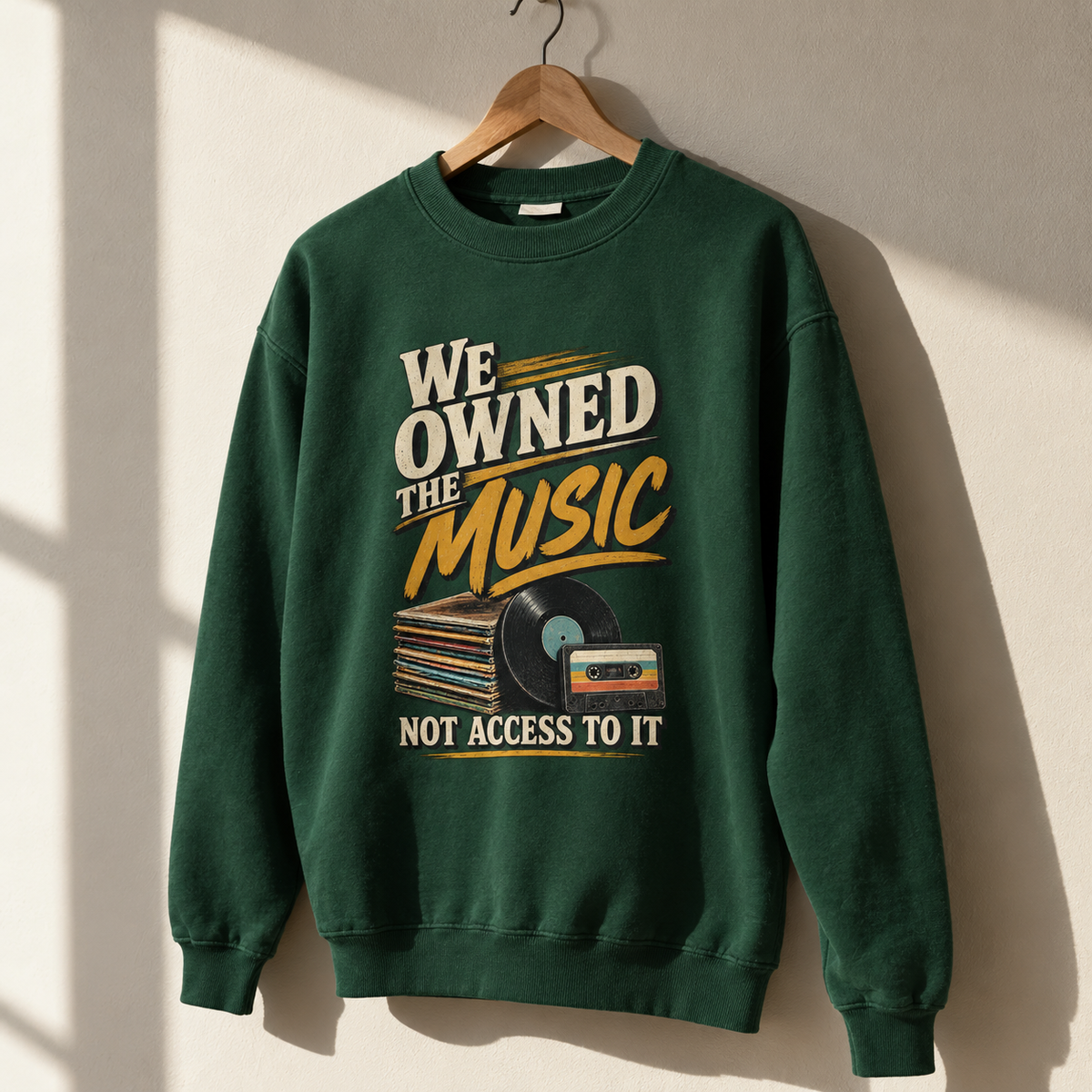 Green vintage sweatshirt hanging with printed music slogan and record designs, front view.
