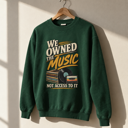 Green vintage sweatshirt hanging with printed music slogan and record designs, front view.