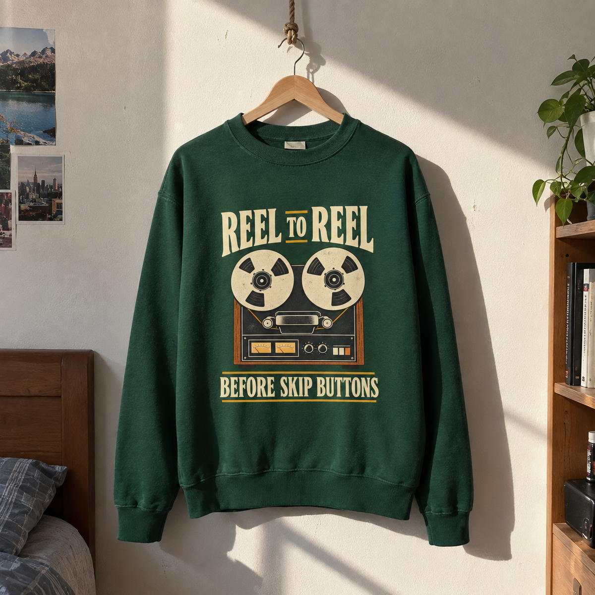 Green vintage sweatshirt hanging with printed reel-to-reel design and “Before Skip Buttons” slogan