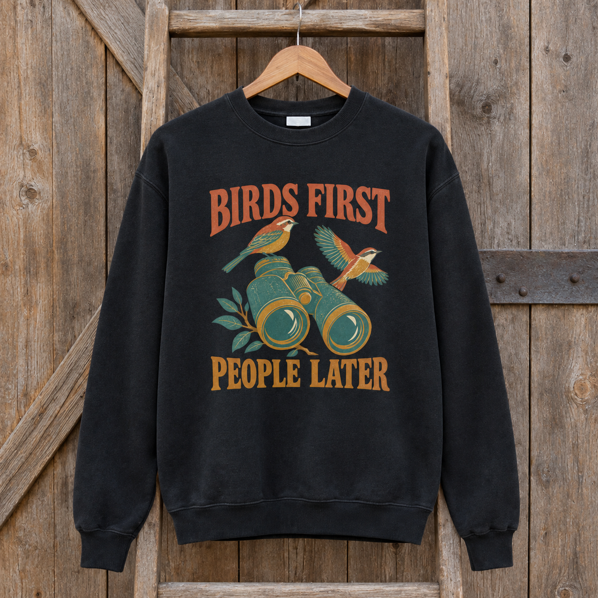 Black vintage sweatshirt hanging with printed Birds First People Later slogan and bird design