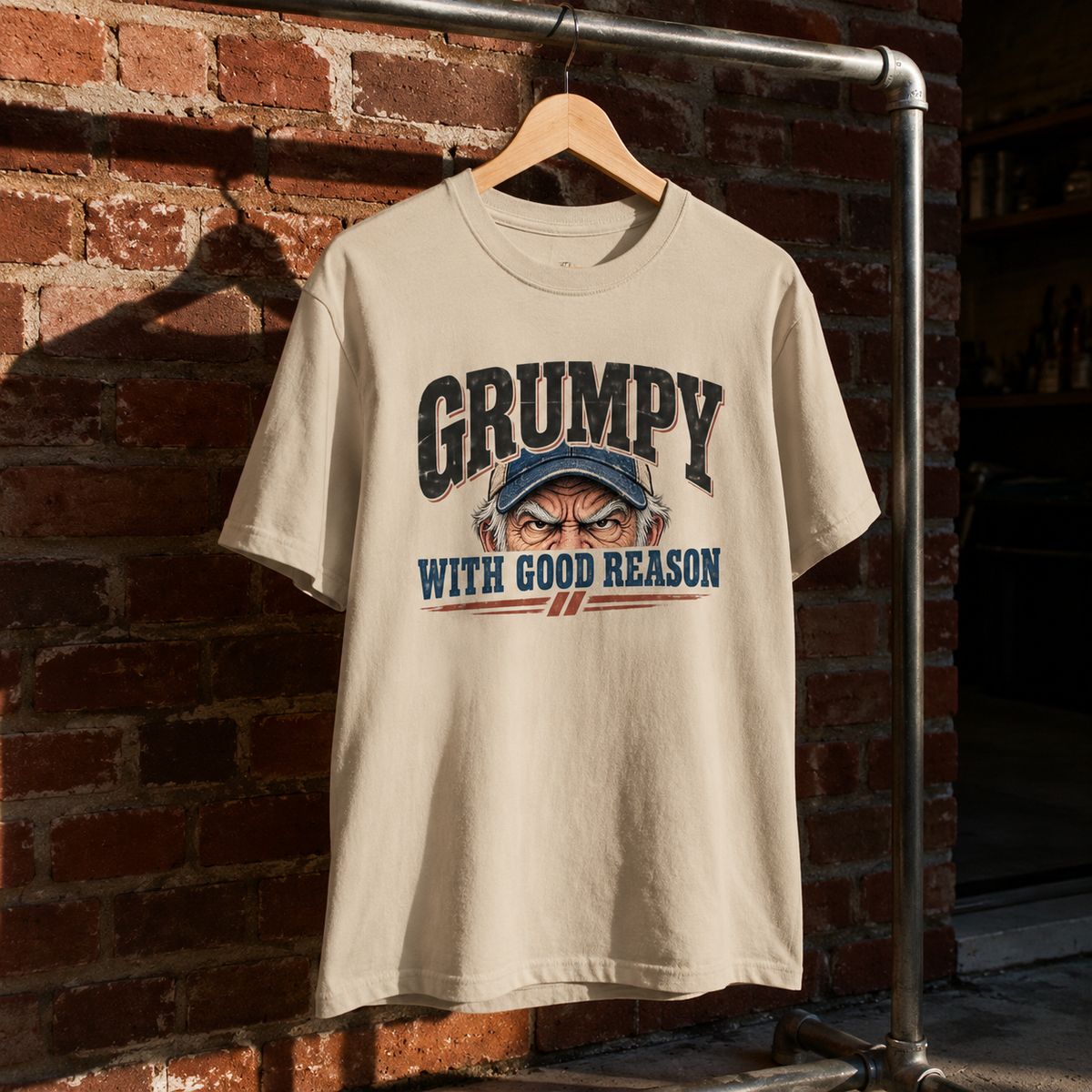 Cream vintage t-shirt with printed Grumpy With Good Reason slogan hanging on brick wall
