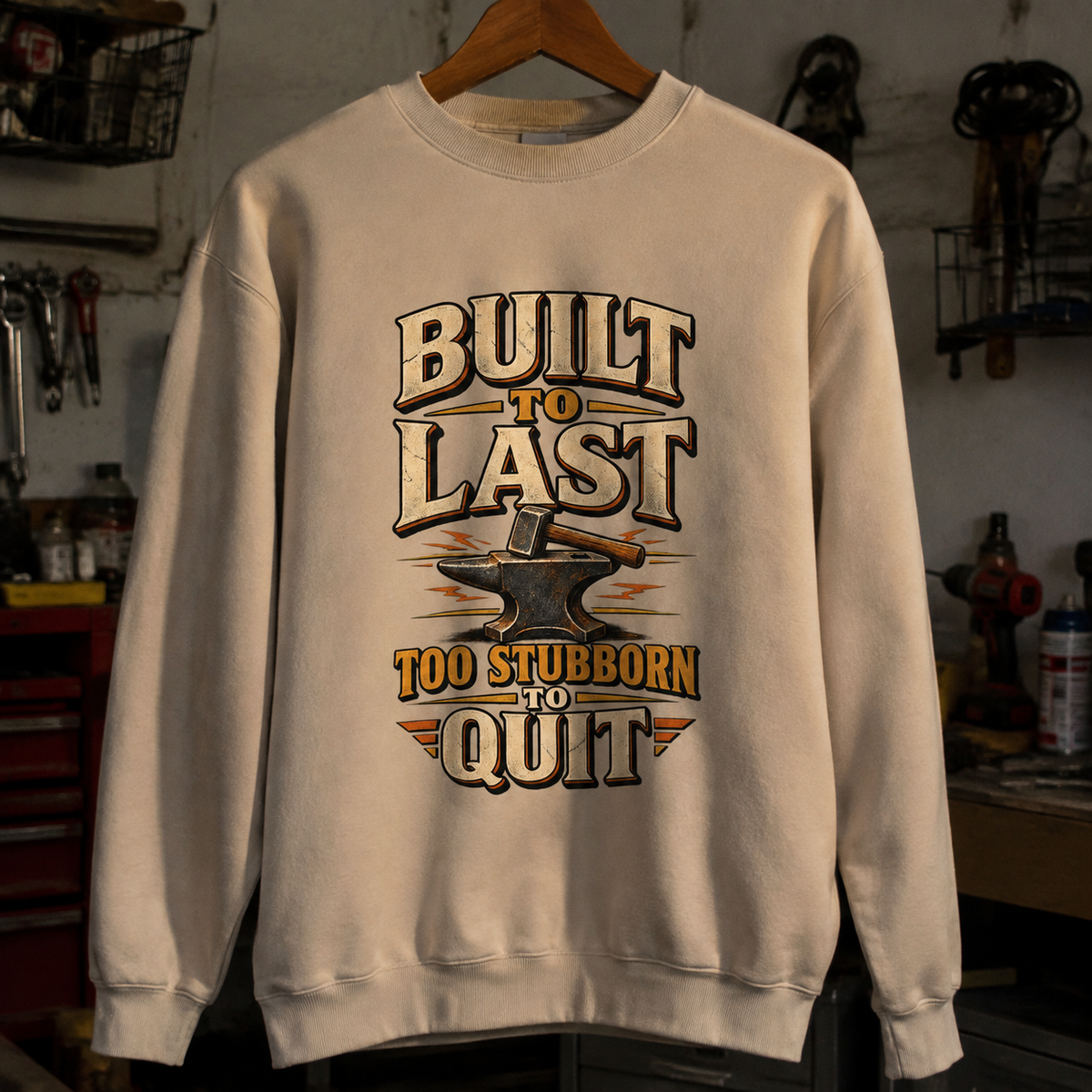 Cream vintage sweatshirt hanging with printed Built To Last Too Stubborn To Quit design
