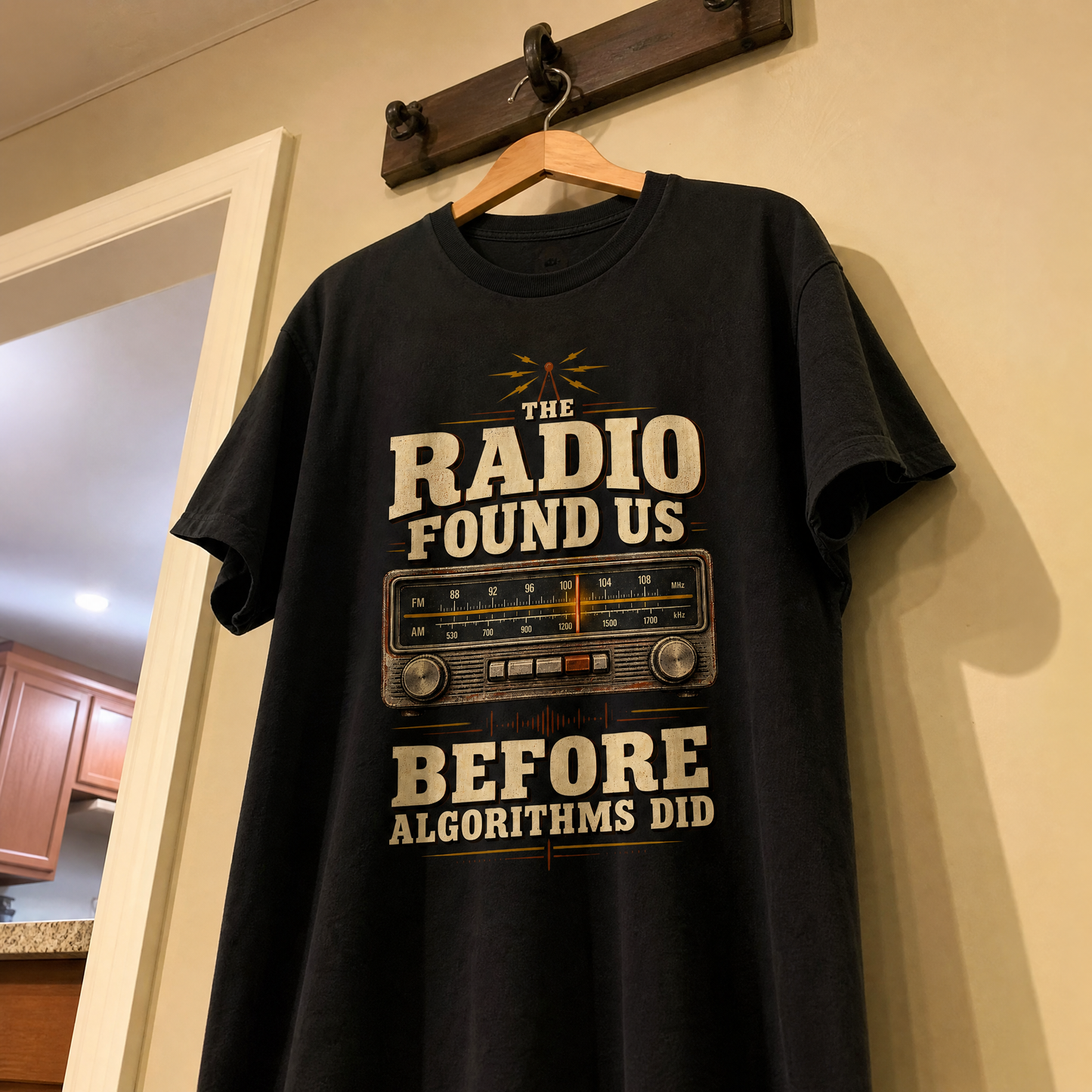 Black vintage t-shirt hanging with printed The Radio Found Us Before Algorithms Did slogan