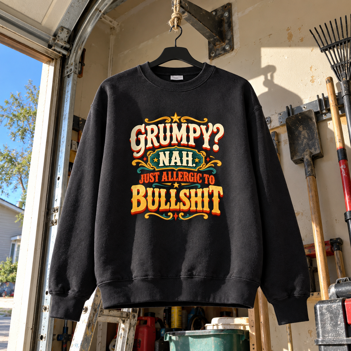 Black vintage sweatshirt hanging in garage with colorful printed “Grumpy? Nah. Just Allergic to Bullshit” slogan
