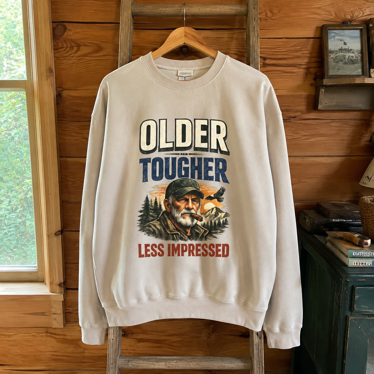 White vintage sweatshirt hanging with Older Tougher Less Impressed printed slogan and senior graphic
