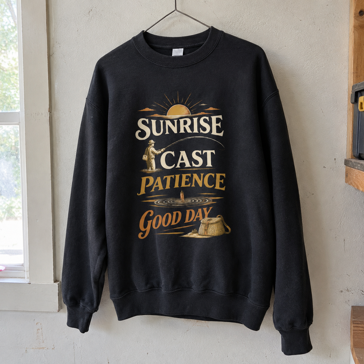Black vintage sweatshirt hanging with printed Sunrise Cast Patience Good Day fishing design