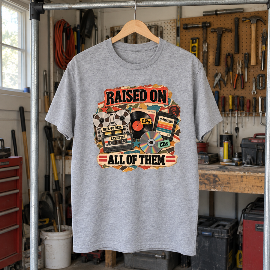 Gray vintage t-shirt hanging in workshop with printed Raised On All Of Them music collage