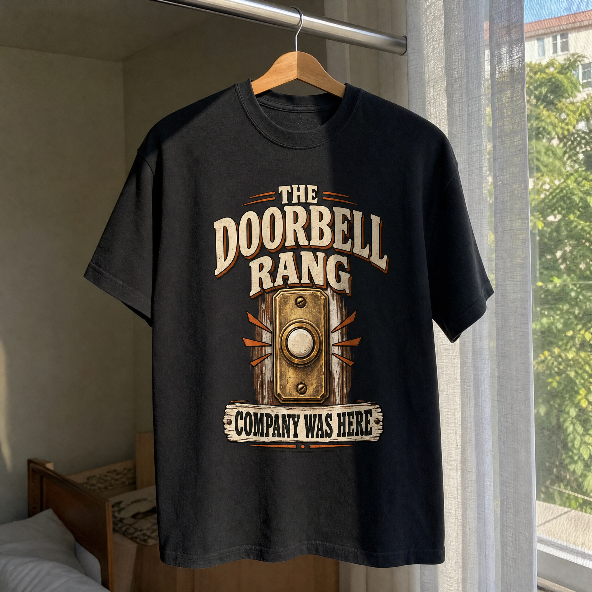 Black vintage t-shirt hanging with printed doorbell design and Company Was Here slogan