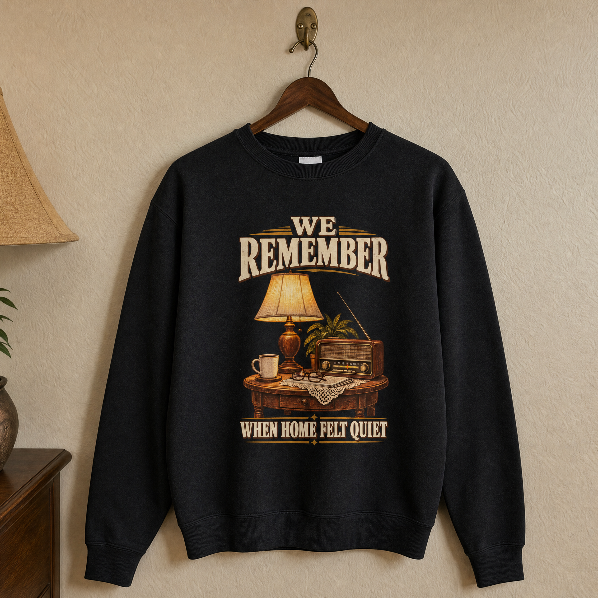 Black vintage sweatshirt hanging with printed retro design reading We Remember When Home Felt Quiet