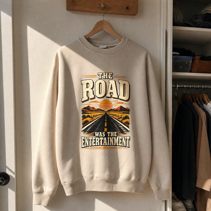 Vintage sweatshirt with printed road design and “The Road Was The Entertainment” slogan hanging in sunlight