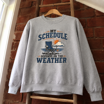 Gray vintage sweatshirt hanging with printed My Schedule Depends On The Weather slogan
