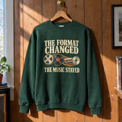 Green vintage sweatshirt with printed music slogan hanging on a wooden wall.