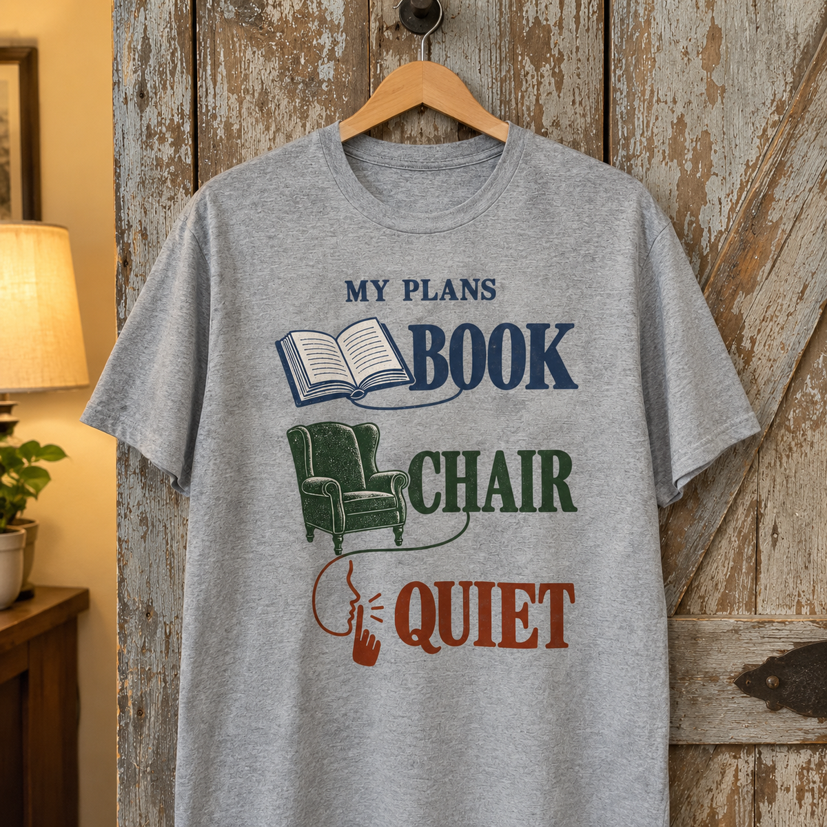 Gray vintage t-shirt hanging, printed with My Plans Book Chair Quiet and book chair graphics.