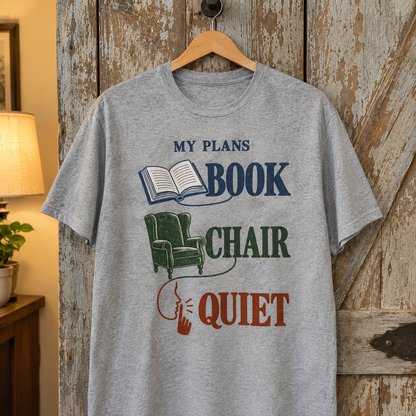 Gray vintage t-shirt hanging, printed with My Plans Book Chair Quiet and book chair graphics.
