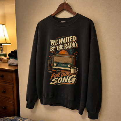 Black vintage sweatshirt hanging with printed “We Waited By The Radio For Our Song” design