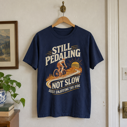 Navy vintage t-shirt hanging with cyclist graphic and “Still Pedaling Not Slow Just Enjoying The Ride” print