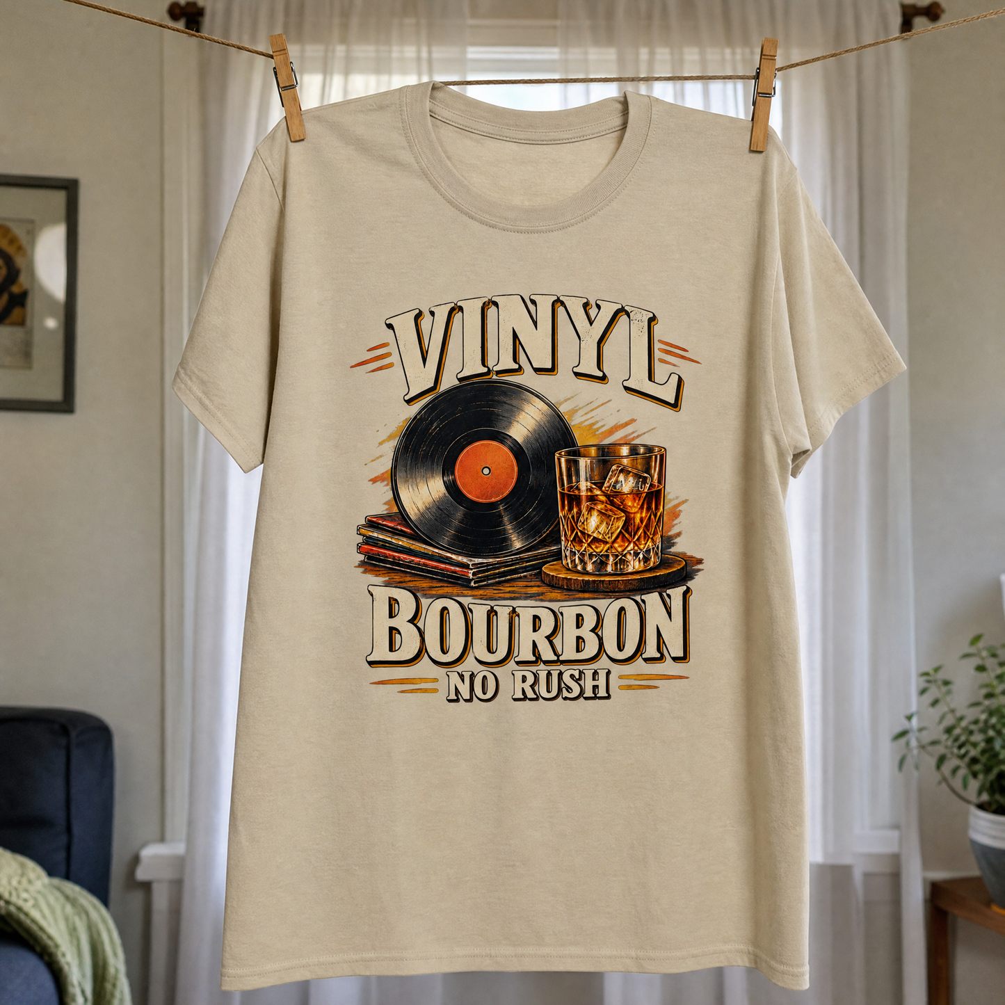 Beige vintage t-shirt hanging with printed Vinyl Bourbon No Rush record and bourbon glass design