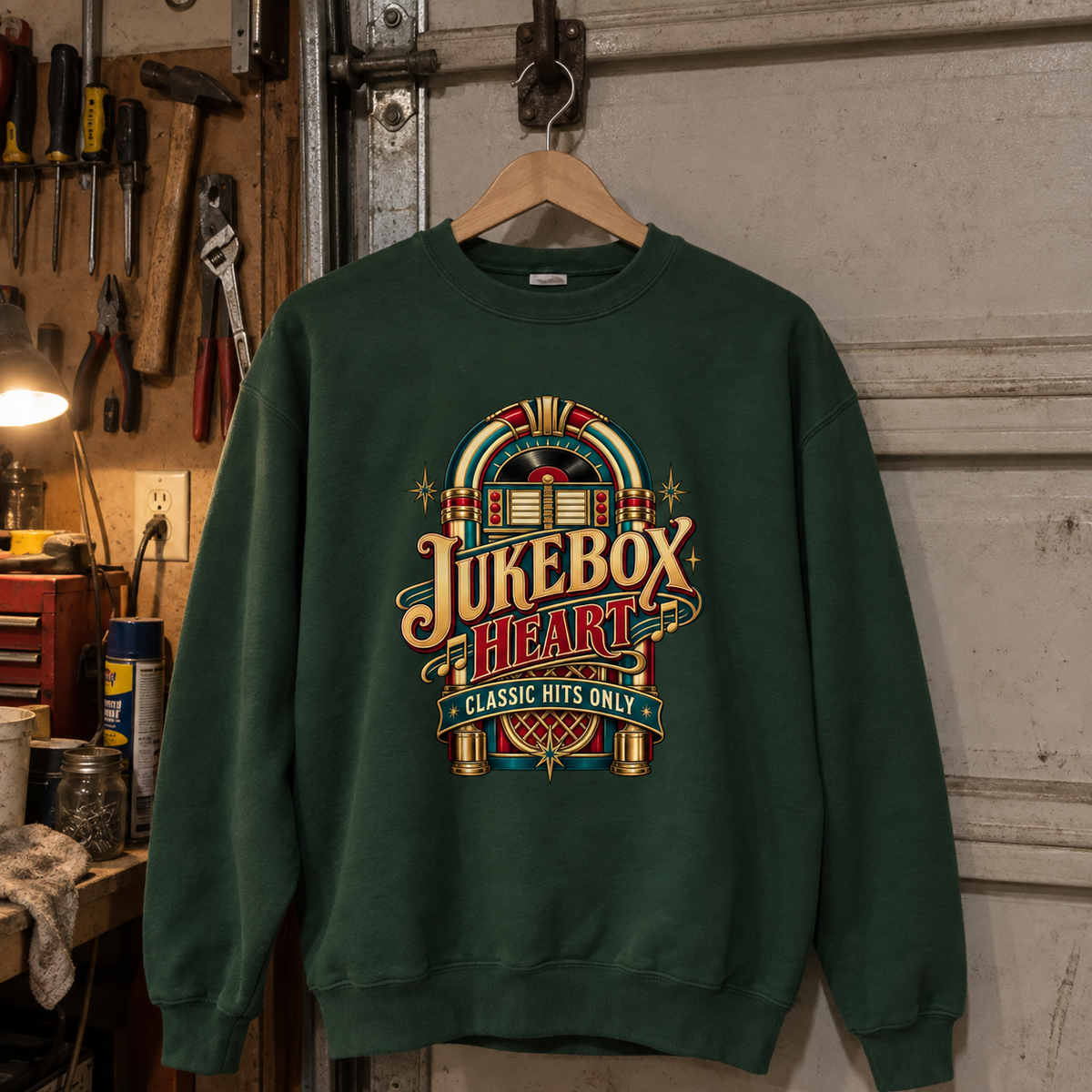 Dark green vintage sweatshirt hanging on a hanger with printed Jukebox Heart Classic Hits Only design