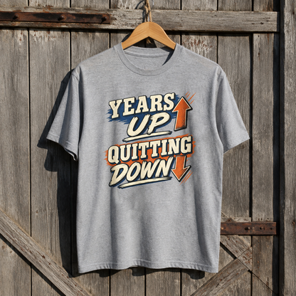 Gray vintage t-shirt hanging with printed “Years Up. Quitting Down” slogan and arrows.