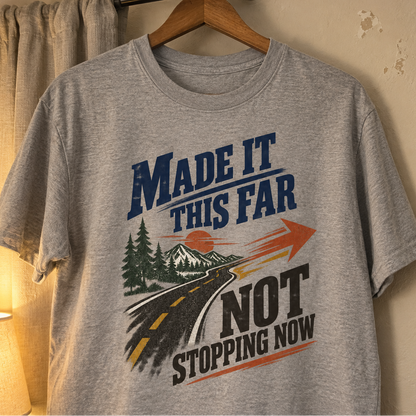 Gray vintage t-shirt hanging, printed Made It This Far Not Stopping Now road design.