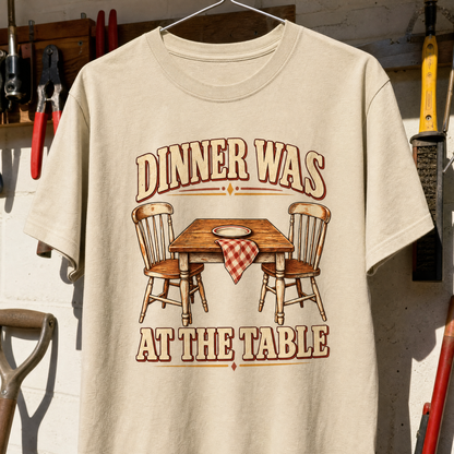 Cream vintage t-shirt hanging with printed “Dinner Was At The Table” and dining table design.