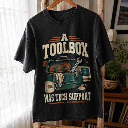 Black vintage t-shirt hanging with printed “A Toolbox Was Tech Support” design