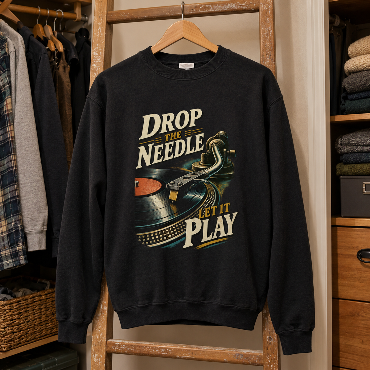 Black vintage sweatshirt hanging with printed “Drop The Needle. Let It Play” design