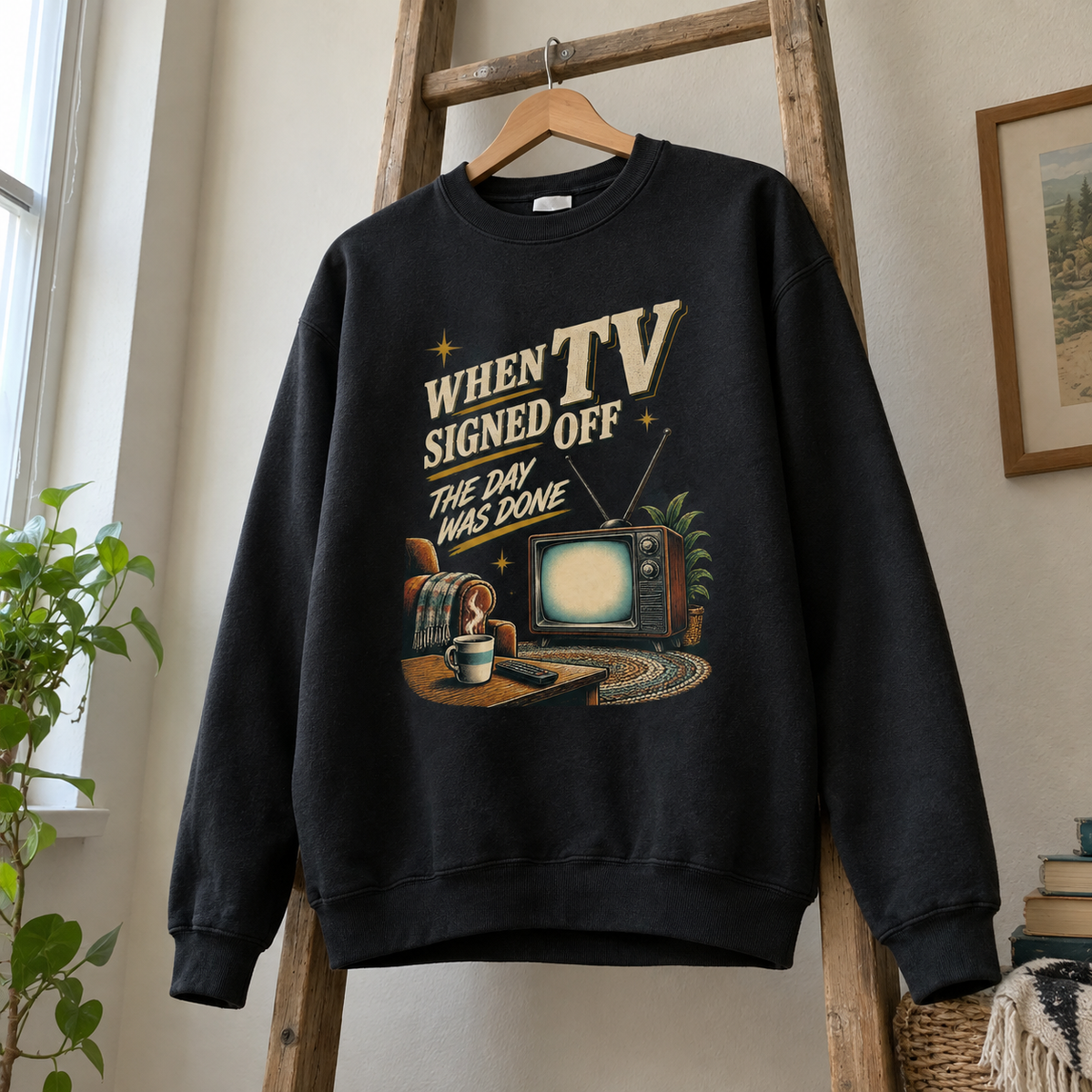 Black vintage sweatshirt hanging, printed with When TV Signed Off The Day Was Done
