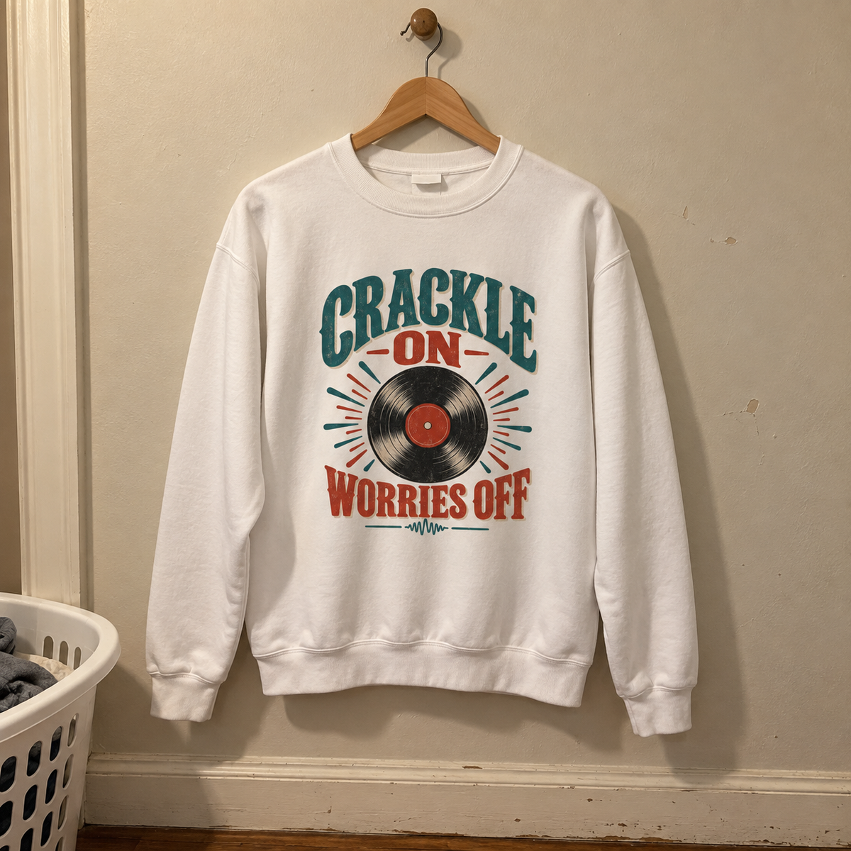White vintage sweatshirt hanging on hanger with printed Crackle On Worries Off vinyl record design