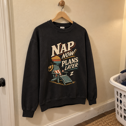 Black vintage sweatshirt hanging on a wooden hanger with printed Nap Now Plans Later design
