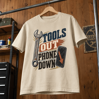 Cream vintage t-shirt hanging with printed Tools Out. Phone Down wrench and phone design.