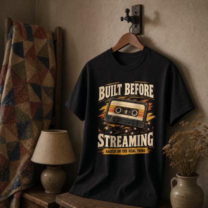 Black vintage t-shirt hanging with printed cassette design and Built Before Streaming slogan.
