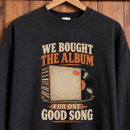 Black vintage sweatshirt hanging on wooden wall, printed with album slogan about one good song