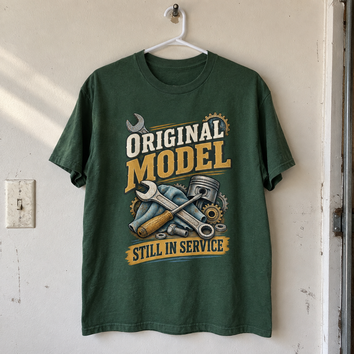 Dark green vintage t-shirt hanging with printed tools and Original Model Still In Service