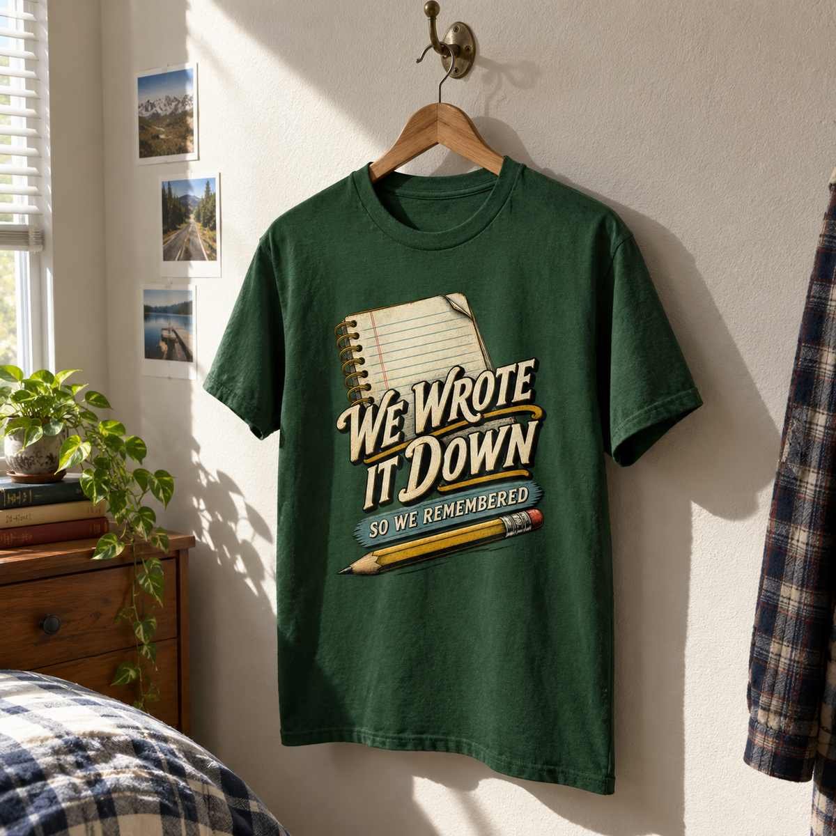Green vintage t-shirt hanging with printed We Wrote It Down So We Remembered