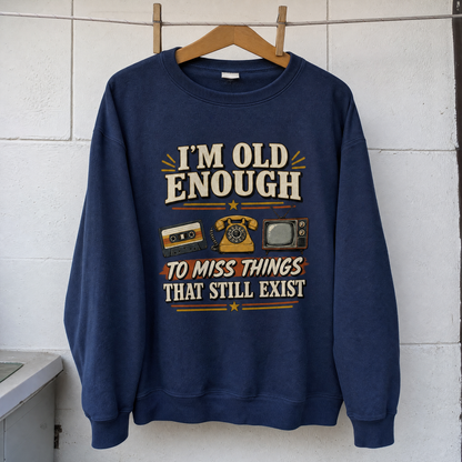 Vintage sweatshirt hanging with printed “42 miss things that still exist” slogan on front