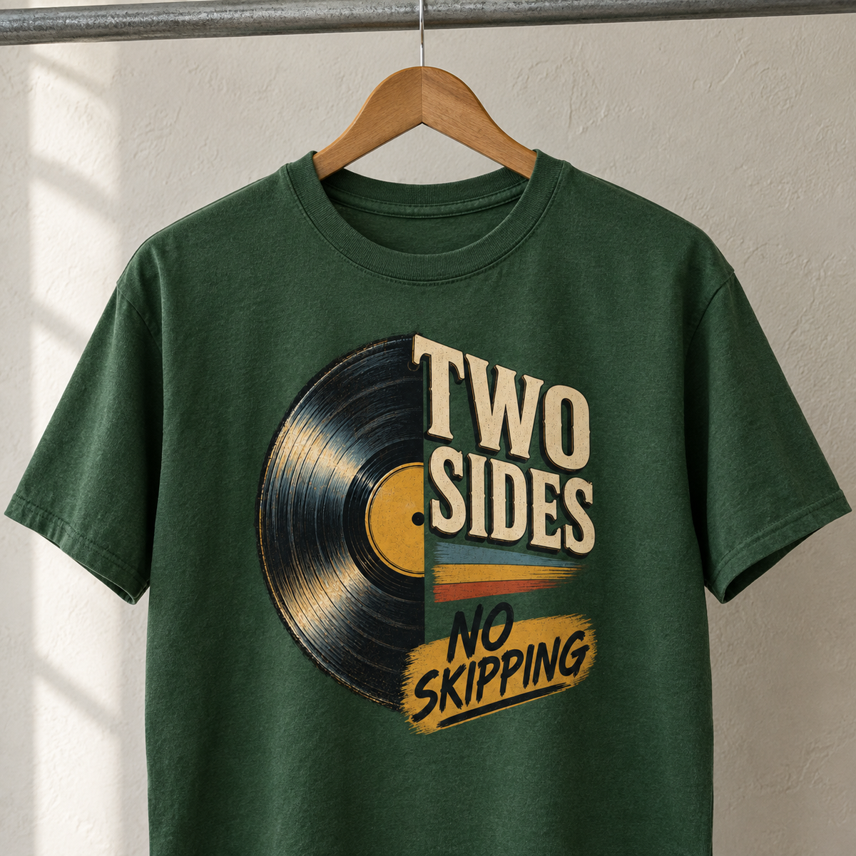 Green vintage t-shirt hanging with printed Two Sides. No Skipping vinyl record design