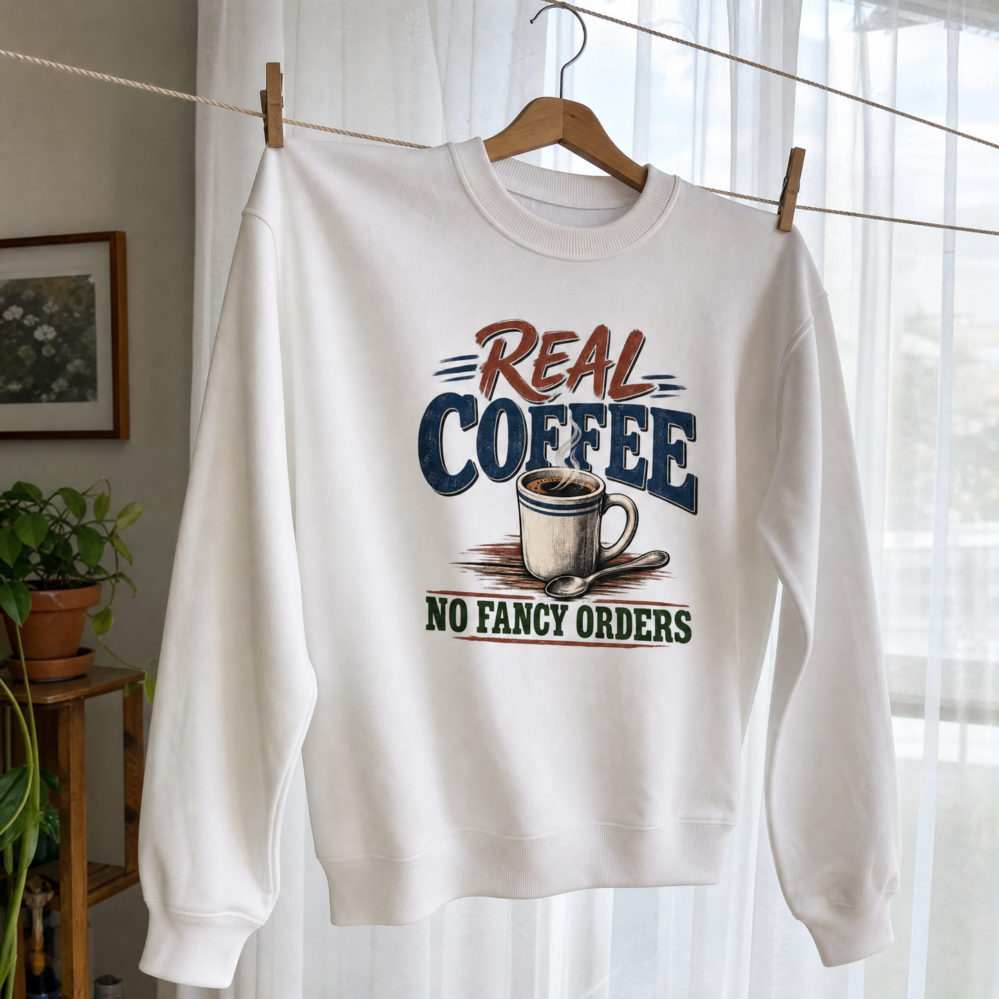 White vintage sweatshirt hanging with printed Real Coffee No Fancy Orders slogan and coffee design