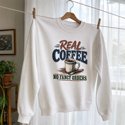 White vintage sweatshirt hanging with printed Real Coffee No Fancy Orders slogan and coffee design
