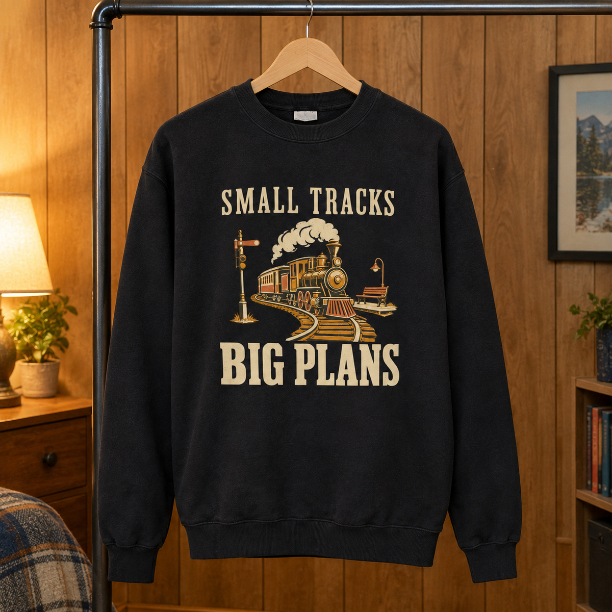 Black vintage sweatshirt with printed Small Tracks Big Plans train design hanging on wooden hanger