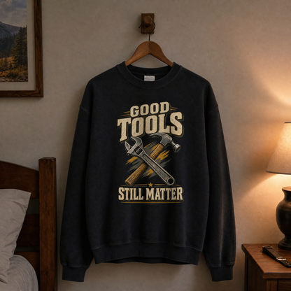 Black vintage sweatshirt hanging with printed Good Tools Still Matter crossed wrench and hammer design.
