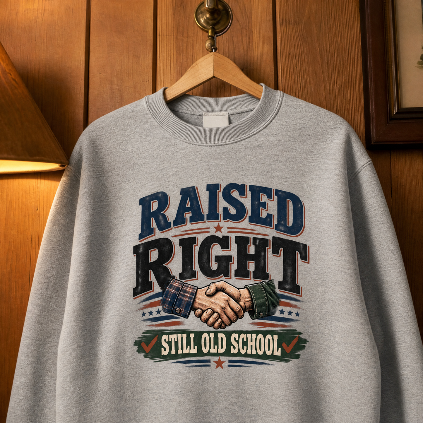 Gray vintage sweatshirt hanging with Raised Right Still Old School printed design