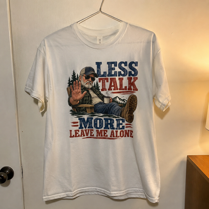 White vintage t-shirt hanging with printed Less Talk More Leave Me Alone slogan design