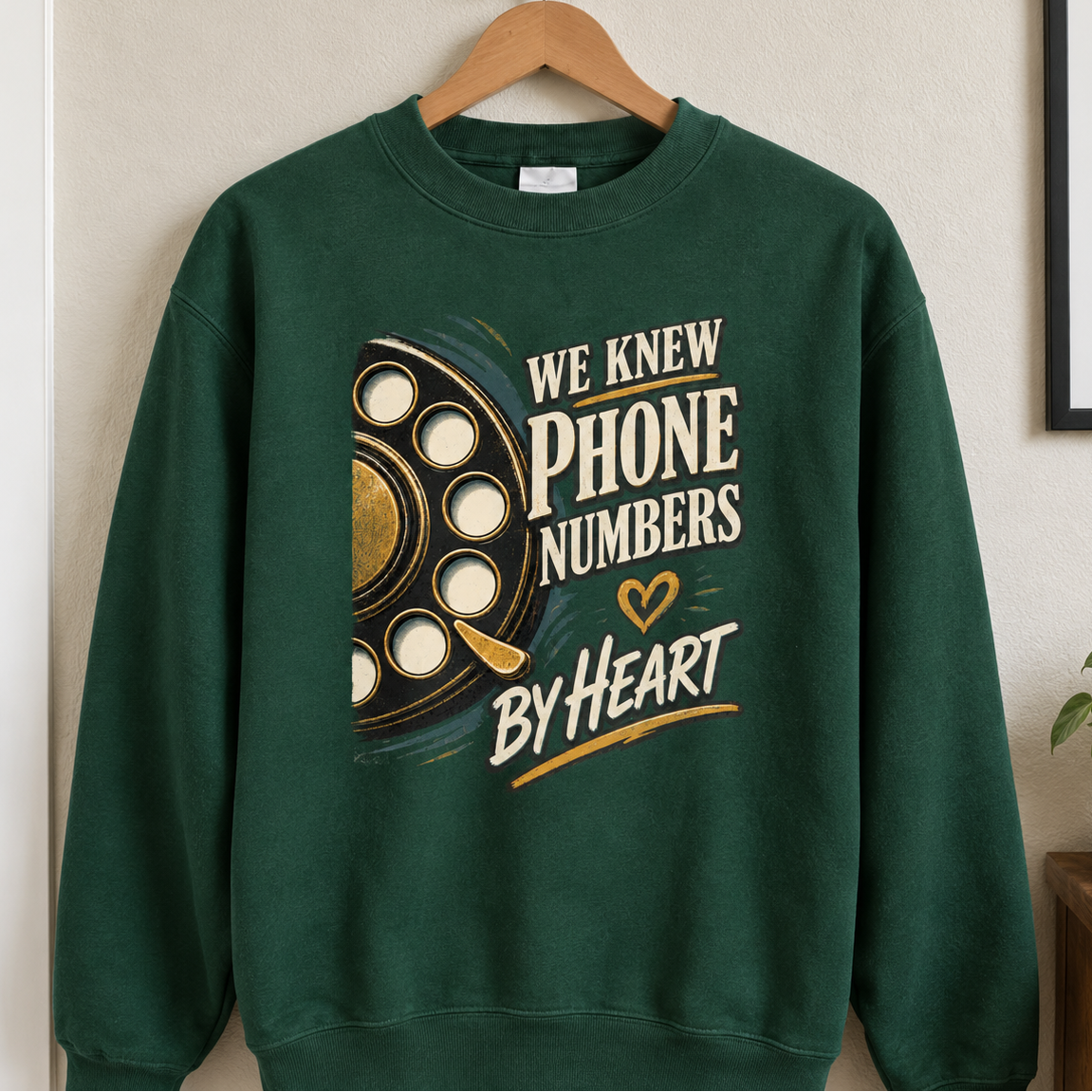 Green vintage sweatshirt hanging on hanger with rotary phone graphic and printed slogan We Knew Phone Numbers By Heart