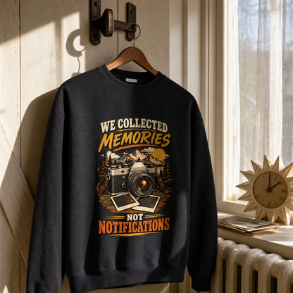 Black vintage sweatshirt hanging, printed with “We Collected Memories Not Notifications” and camera mountain design.