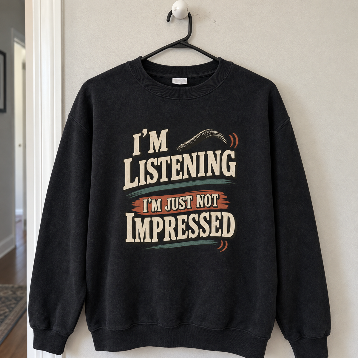 Black vintage sweatshirt hanging on a hanger with printed I'm Listening I'm Just Not Impressed slogan